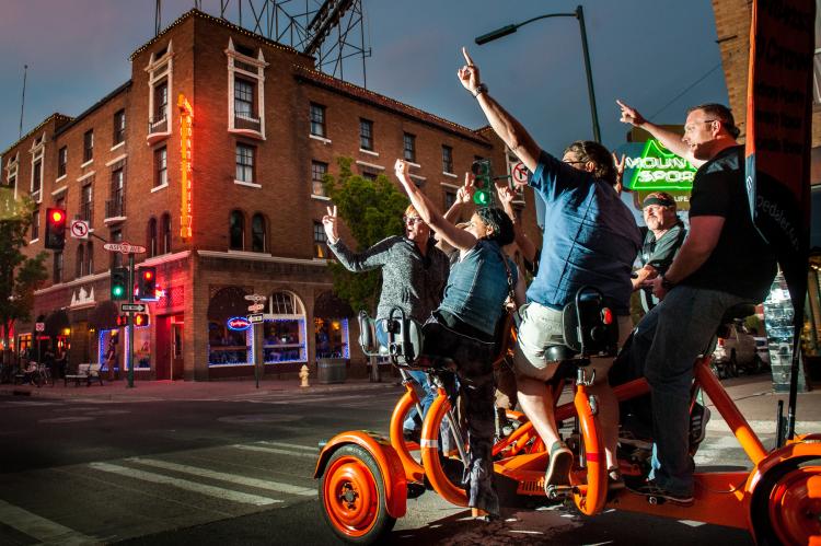 A group rides a pedaler from Alpine Pedaler while visiting different Flagstaff, AZ breweries