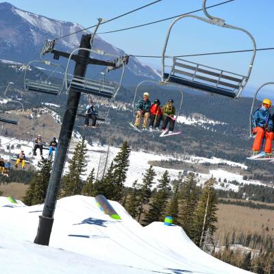 skiers riding ski lift