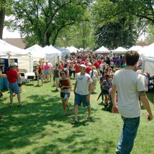 A crowd of people walk around local vendors during Art In The Park.