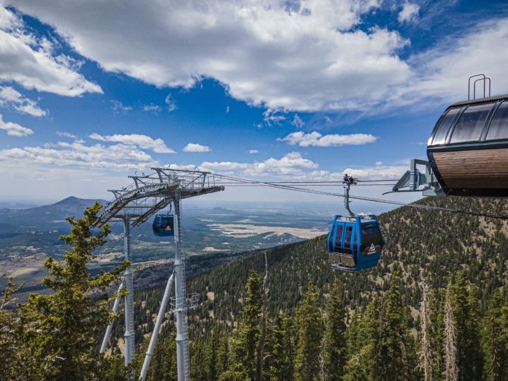 The summer gondola ride above tall pine trees at the Flagstaff Arizona Snowball in Flagstaff, AZ.