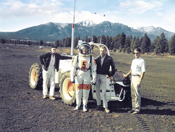 Vintage photo of group, one man dressed in astronaut suite completing Lunar Legacy tour in Flagstaff, AZ
