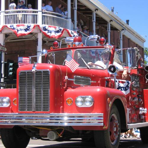 A vintage firetruck driving through downtown Flagstaff during the 4th of July Parade.