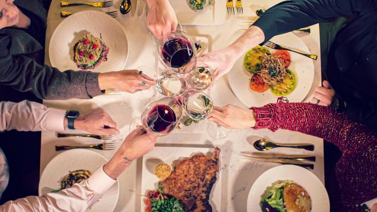 People cheering with wine and food at Teatro in Flagstaff, AZ.